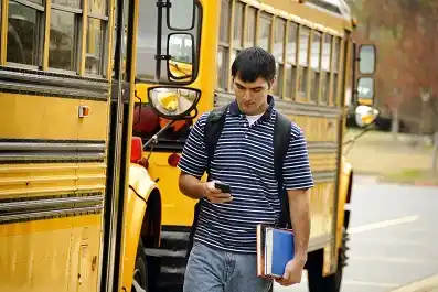 Teen walking while texting on his phone